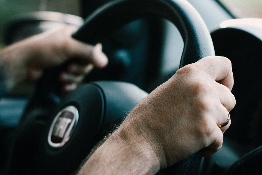 mains posées sur un volant de voiture