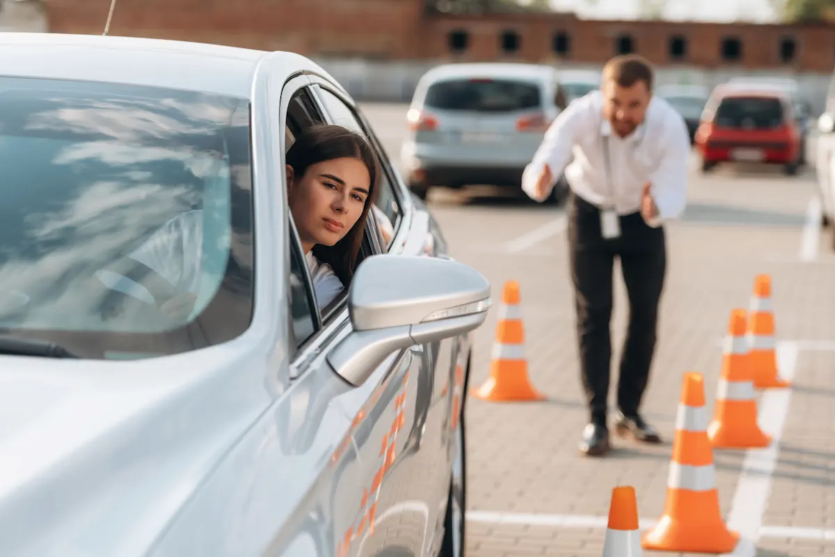 Un homme qui apprend à conduire avec des cônes de signalisation