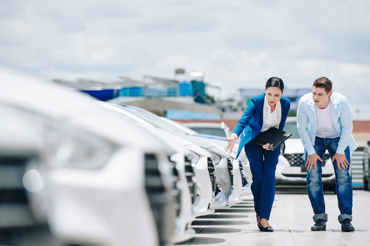 Un mandataire auto qui montre un modèle à un homme