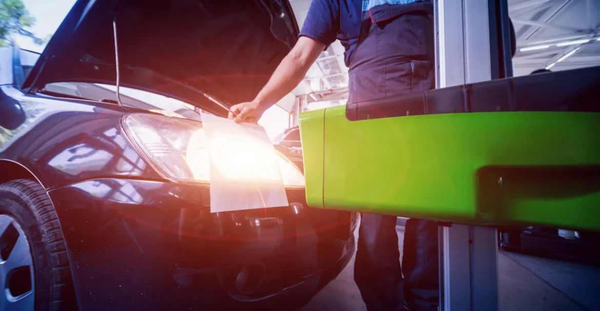 Un homme qui teste un anti-brouillard avant de voiture pendant un contrôle technique