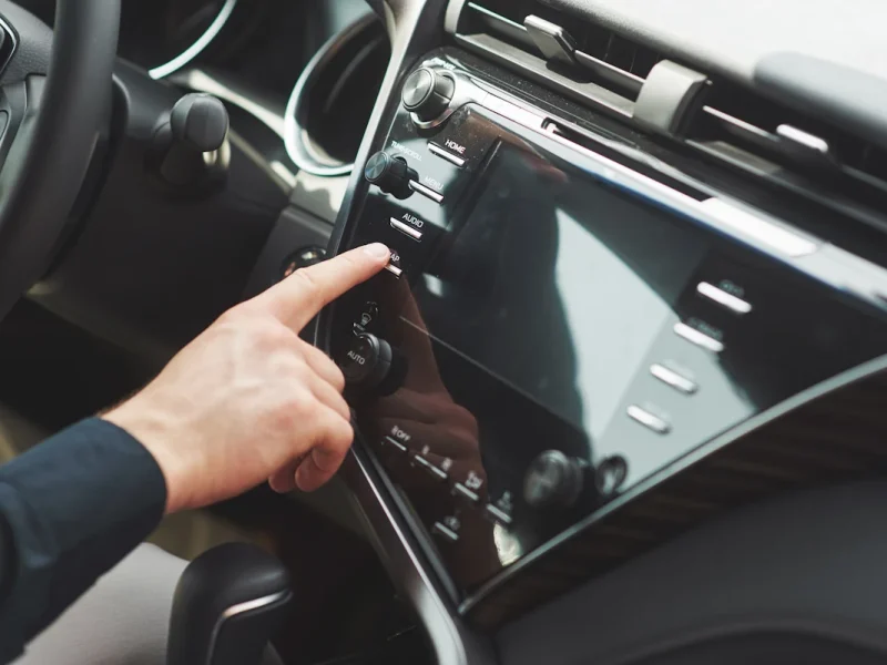 Une personne qui met en marche l'autoradio d'une voiture
