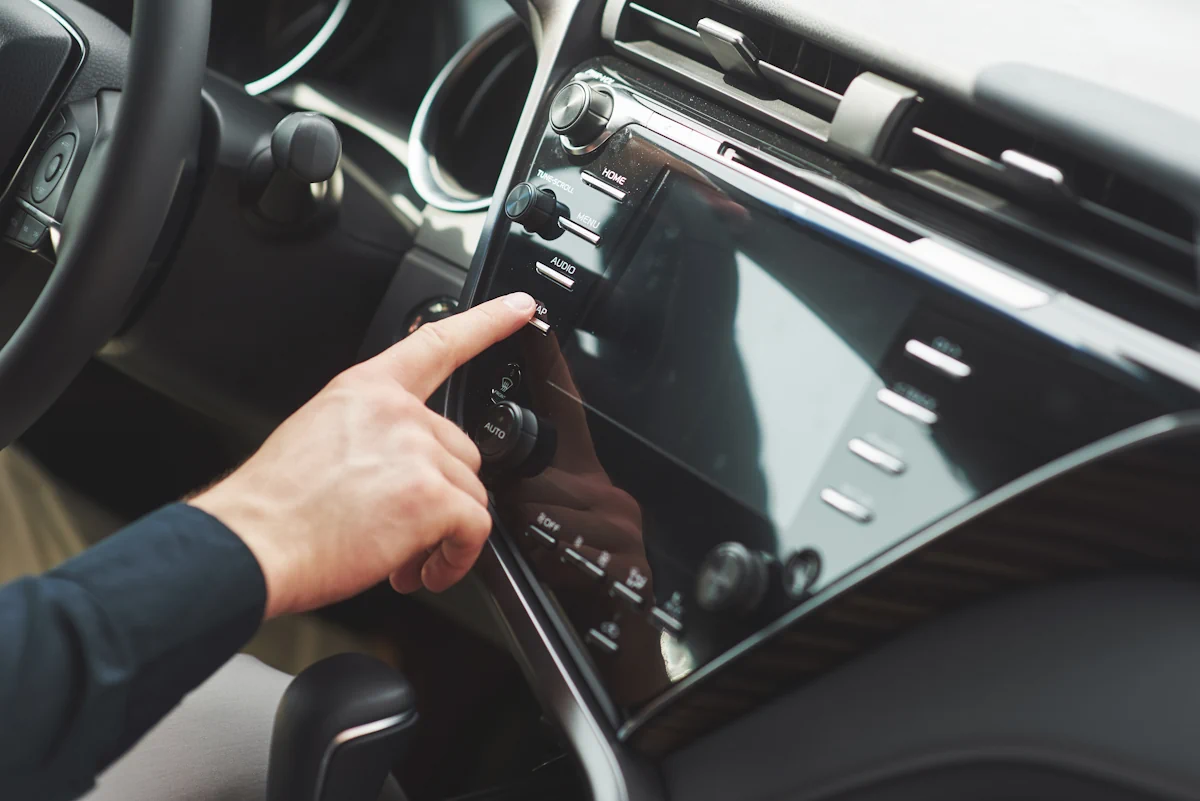 Une personne qui met en marche l'autoradio d'une voiture