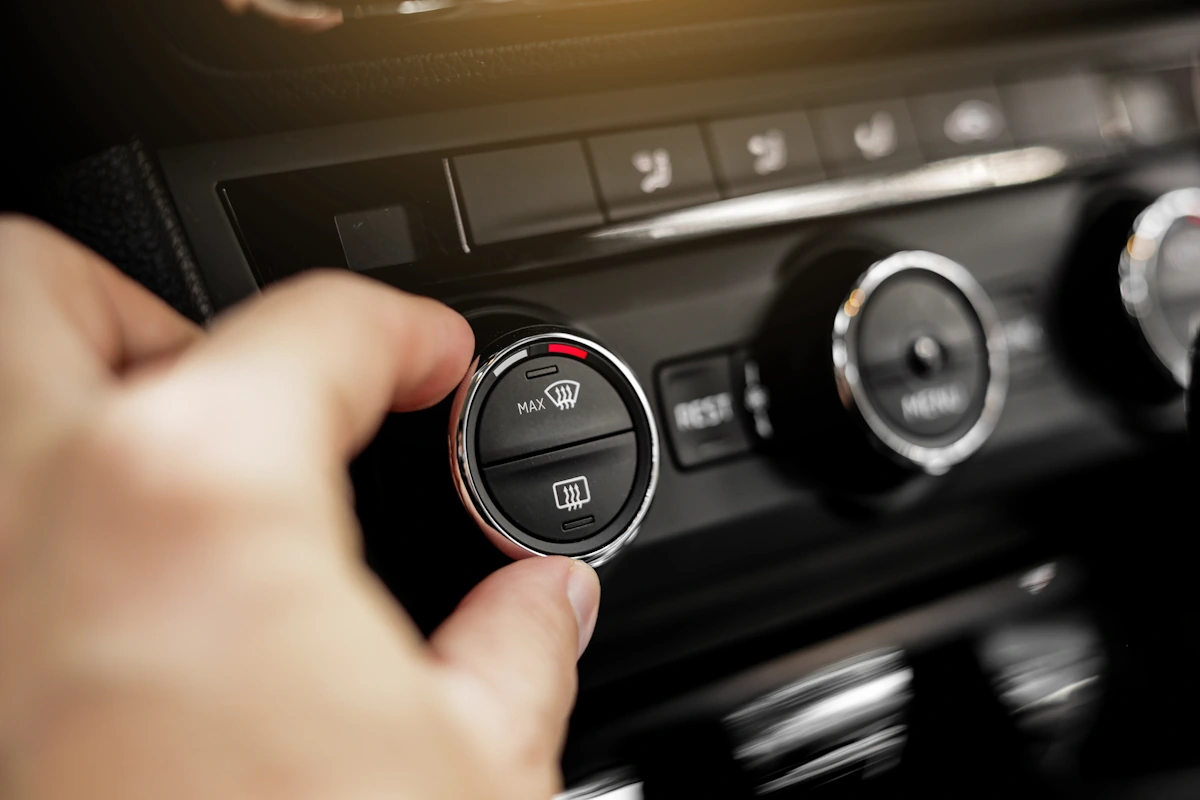 Une personne qui démarre une clim de voiture