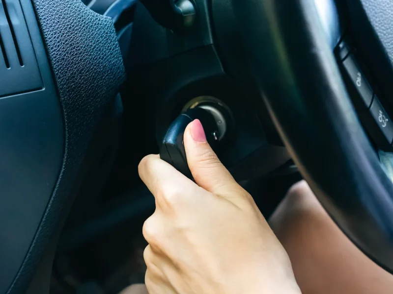 Une personne qui démarre une voiture