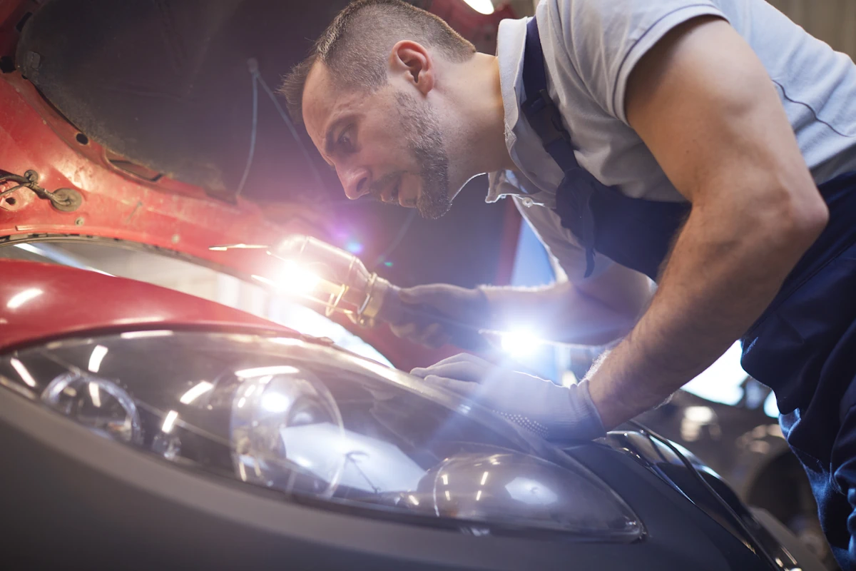 Un homme qui règle un phare de voiture neuf