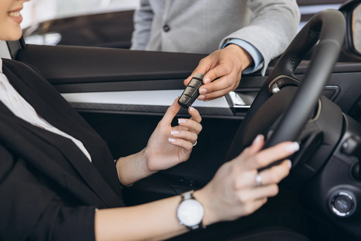 Une femme qui prend une clé de voiture tendue par un serrurier automobile